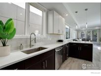 Modern kitchen featuring stainless steel appliances, a subway tile backsplash, and ample counter space with a living area view at 726 Pearl St # B, Boulder, CO 80302