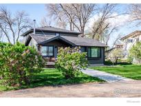 Charming home with a well-manicured lawn, blooming lilac bushes, and a welcoming walkway at 7800 Hygiene Rd, Longmont, CO 80503