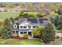 Charming two-story home with blue shutters, complemented by lush landscaping and solar panels at 8924 Prairie Knoll Dr, Longmont, CO 80503