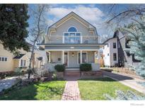 Charming two-story home with a welcoming front porch and balcony overlooking the landscaped yard at 1013 4Th Ave, Longmont, CO 80501