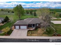Expansive ranch home with a three car garage and a well manicured lawn at 11669 Montgomery Cir, Longmont, CO 80504