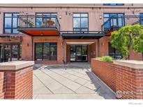 A building entrance featuring brick architecture and well-maintained landscaping at 1360 Walnut St # 211, Boulder, CO 80302