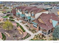 A row of townhomes with well-maintained landscaping, walkways, and attractive architectural details at 1831 Kalel Ln, Louisville, CO 80027