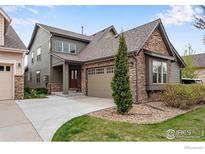 Charming two-story home featuring stone accents, a well-maintained lawn, and a two-car garage at 2210 Calais Dr # B, Longmont, CO 80504
