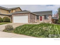Charming brick home with a well-maintained lawn and a two-car garage, complete with a red front door at 2680 Bryant Dr, Broomfield, CO 80020