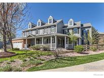 Charming two-story home featuring a welcoming front porch and well-manicured lawn on a sunny day at 2862 Flint Ct, Superior, CO 80027