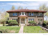 Charming stone home with a red tile roof, manicured lawn, and inviting walkway at 2935 19Th St, Boulder, CO 80304