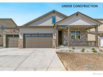 New construction home with stone accents, a covered front porch, a three-car garage and a concrete driveway at 4316 Gypsum Ave, Mead, CO 80504