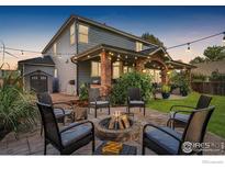 Outdoor patio with fire pit and string lights, perfect for entertaining in a landscaped backyard at 505 Saint Andrews Dr, Longmont, CO 80504