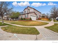 Charming two-story home featuring well-manicured lawn, brick accents, and an attached two-car garage at 5355 Killdeer St, Brighton, CO 80601