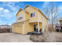 Charming yellow two-story home with inviting front porch and well-maintained landscaping at 740 Boxwood Ln, Longmont, CO 80503
