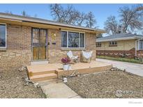 Charming brick home exterior featuring a cozy front porch and manicured yard at 7950 Maria St, Westminster, CO 80030