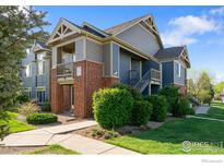 Inviting condo exterior featuring brick accents, well-maintained landscaping, and a charming covered entry at 804 Summer Hawk Dr # 11208, Longmont, CO 80504