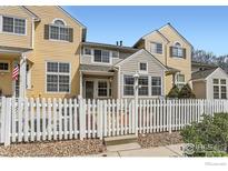 Charming two-story home featuring a white picket fence and a welcoming front patio at 827 Snowberry St, Longmont, CO 80503