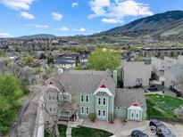 Stunning aerial view of a charming green home with red accents nestled in a scenic, mountain view neighborhood at 1203 6Th St # 1203, Golden, CO 80403