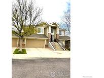 Attractive multi-level home with a two-car garage and an inviting entrance with steps leading to the front door at 13873 Legend Way # 103, Broomfield, CO 80023