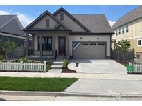 Charming two-story home with covered porch, manicured lawn, and neutral color palette, providing excellent curb appeal at 1641 Poplar Dr, Erie, CO 80516