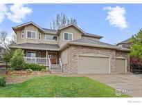 Charming two-story home featuring a stone and siding exterior with a spacious three-car garage and inviting front porch at 2275 Schooner St, Lafayette, CO 80026