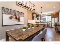 Bright dining area leading to a modern kitchen with stainless steel appliances and bar seating at 2465 Walnut St # 7, Boulder, CO 80302