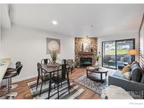 Inviting living room features a stone fireplace, wood floors, and sliding glass doors to a patio at 2727 Folsom St # 228, Boulder, CO 80304