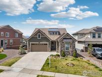 Charming home featuring a well-manicured lawn, attached garage, neutral paint and stone facade accents, and new roof at 3047 Grizzly Peak Dr, Broomfield, CO 80023