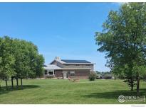 Charming two-story home featuring solar panels and a well-manicured lawn at 524 E County Road 8, Berthoud, CO 80513