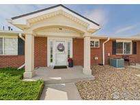 Welcoming front door with peaked roof and small walkway and garden at 5425 County Road 32 # 15, Mead, CO 80504
