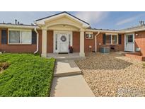 Charming front entrance with a brick facade, covered porch, and well-manicured landscaping at 5425 County Road 32 # 15, Mead, CO 80504