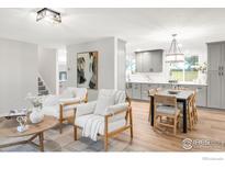 Bright, open-concept living and dining area with hardwood floors and stylish, modern decor at 6877 Gray Dr, Arvada, CO 80003