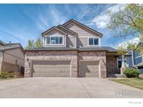 Charming two-story home featuring a brick facade and a three-car garage at 10583 Oakmoor Cir, Parker, CO 80134