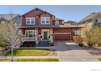 Charming two-story home with a covered porch and a two-car garage at 13360 W 83Rd Pl, Arvada, CO 80005