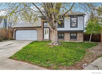 Charming two-story home with a brick facade, well-maintained lawn and a spacious two-car garage at 13755 W 65Th Dr, Arvada, CO 80004