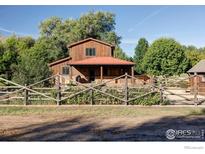 Charming two-story home with a red roof, wooden fence and lush landscaping on a sunny day at 15789 N 83Rd St, Longmont, CO 80503