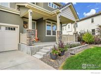 Charming front porch with stone pillars, a wreath, and autumn decor offers inviting curb appeal at 16060 Fairway Dr, Commerce City, CO 80022