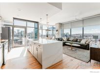 Bright, open-concept living space with hardwood floors, floor-to-ceiling windows, and views of the cityscape at 1700 Bassett St # 1808, Denver, CO 80202