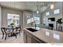 Open-concept kitchen featuring quartz countertops, a modern sink, and stainless steel appliances at 208 High Point Dr, Longmont, CO 80504