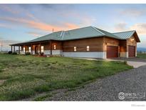 Stunning home exterior showcasing a metal roof, wood siding and an attached garage with mountain views at 2139 S County Road 15, Berthoud, CO 80513