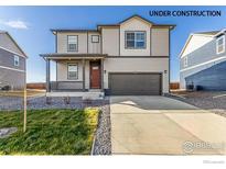 Charming two-story home featuring a covered porch and an attached two-car garage at 2231 Crosswind St, Fort Lupton, CO 80621