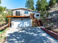 Charming home with a wooden deck above a two-car garage and a hillside setting at 2345 Point Of Pines Dr, Boulder, CO 80302