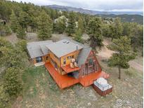 Beautiful A-frame home with a large deck, hot tub, and stunning mountain views surrounded by lush trees at 291 Canon View Rd, Boulder, CO 80302