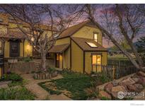 Charming two-story home with a well-maintained yard and a picket fence, set against a backdrop of rolling hills at 3550 Smuggler Cir, Boulder, CO 80305
