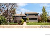 Contemporary two-story home featuring wood siding, a well-manicured lawn, and a welcoming front walkway at 3809 Howe Ct, Boulder, CO 80301