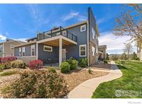 Charming two-story home featuring a balcony, front yard, stone accents and well maintained landscaping at 671 Robert St, Longmont, CO 80503