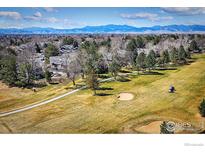 Aerial view showing golf course community, well-manicured landscaping, and mountain views at 8403 Chase Dr, Arvada, CO 80003