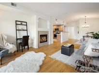 Bright living room featuring a fireplace, hardwood floors, and an open layout perfect for modern living at 1122 Olympia Ave # 12H, Longmont, CO 80504