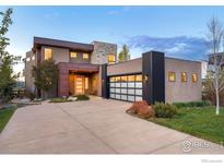 Striking contemporary home with a three-car garage, warm exterior lighting, and a well-manicured front yard at 1135 Redwood Ave, Boulder, CO 80304