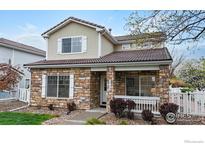 Charming two-story home with a stone facade, inviting front porch, and well-maintained landscaping at 11738 Zenobia Loop, Westminster, CO 80031