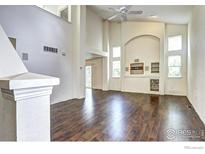 Bright living room boasts high ceilings, hardwood floors and built-in shelves for storage and decor at 1438 Stockton Dr, Erie, CO 80516
