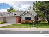 Charming home featuring a brick and siding exterior, well-maintained lawn, and an attached garage at 1609 16Th Pl, Longmont, CO 80501