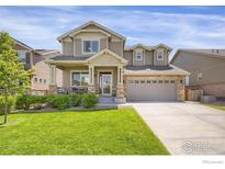 Charming two-story home with a well-manicured lawn, covered porch, and attached two-car garage at 17052 Lipan St, Broomfield, CO 80023